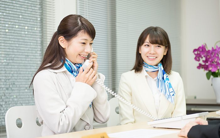 電話通話する受付女性２人