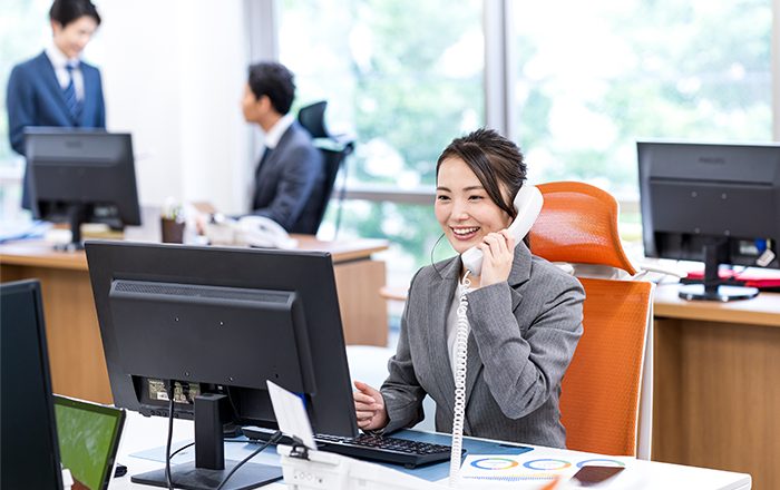 オフィスで電話する女性スタッフ