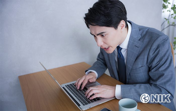 PCに向かい入力漏れ確認に奮闘する「なんでも担当者」さん。イメージ