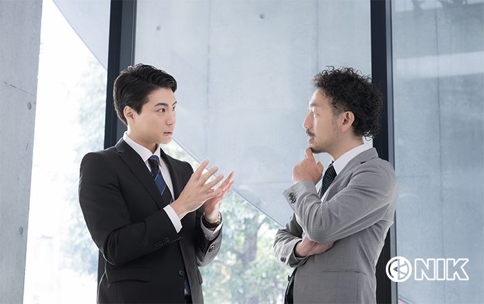 口頭で同僚社員に説明している「なんでも担当者さん」イメージ。