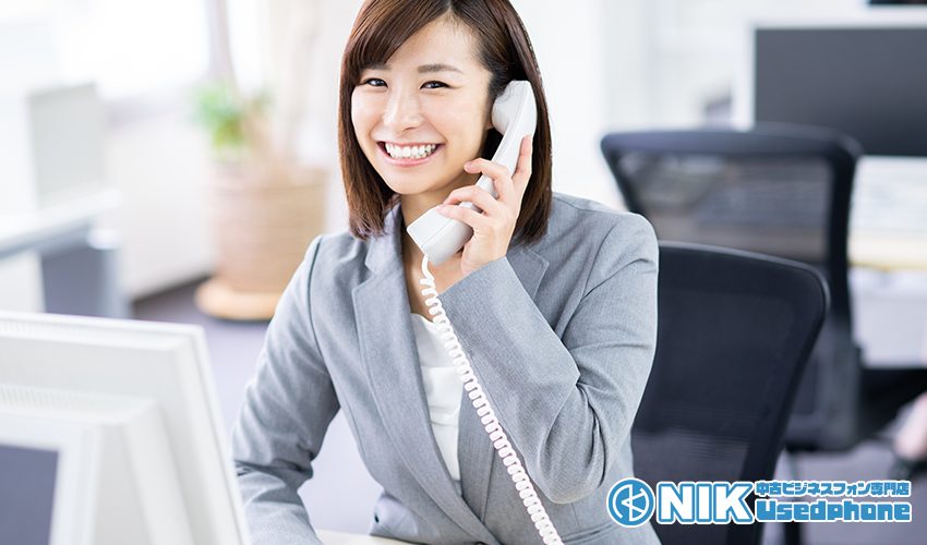 中古ビジネスフォンで通話する女性