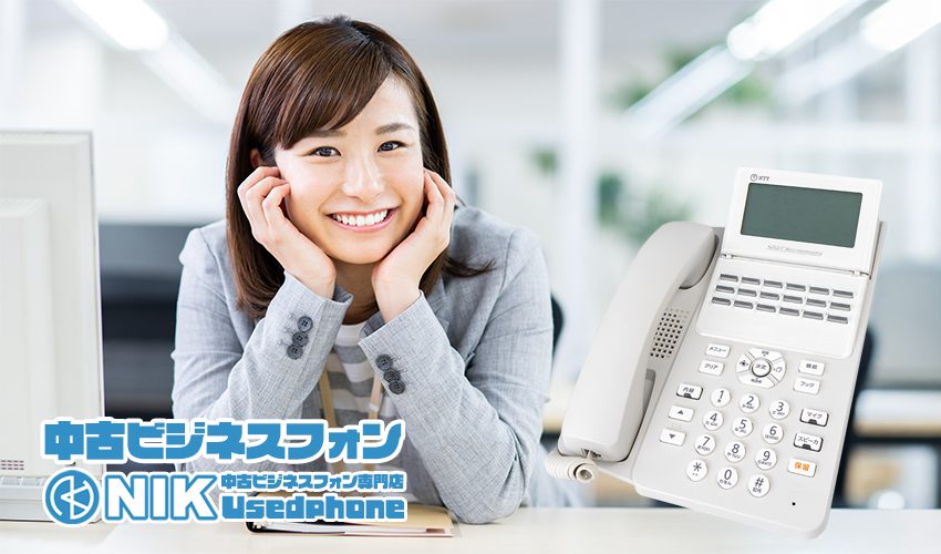 笑顔の女性と中古ビジネスフォン