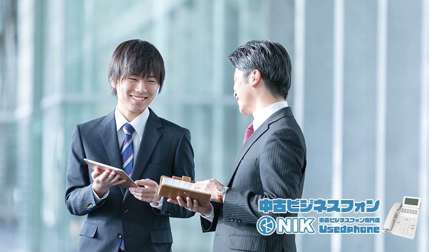 ビジネス会話する若い男性と中年の男性「中古ビジネススフォン・NIK中古ビジネスフォン専門店Usedphone」